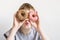 Teen boy looks into donut holes and funny grimaces