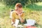 The teen boy is lying on the grass and reading books.