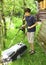 Teen boy moving grass lawn witm mover