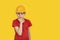 Teen boy in an orange helmet on yellow background. Brooding serious guy in hardhat. Copy space