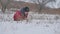 Teen boy rolling a ball of snow to build a winter fortress. sculpts snowman snow