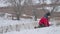 Teen boy rolling a ball of snow to build winter a fortress. sculpts snowman snow