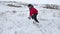 Teen boy rolling a ball of winter snow to build a fortress. sculpts snowman snow