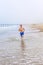 Teen boy runs along the beach