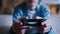 teen boy sitting on the sofa and playing playstation, joystick close-up, cinematic shot