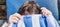 A teen boy upset, covers his face with beach towel. close-up of face and hands. portrait of a frustrated teenager