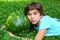 Teen boy with whole water melon lay on green grass