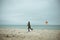 Teen brother and sister playing with kites in sand dunes of Baltic coastline