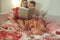 Teen brother and sister reading book in bed