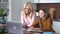 Teen child daughter studying at home in kitchen with mom.