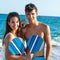 Teen couple with beach tennis rackets.