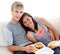 Teen couple eating burgers and fries at home