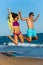 Teen couple in swim wear jumping.