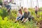 Teen daughter helps mother clean weeds in garden beds