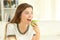 Teen eating an apple on a couch at home