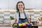 Teen girl in apron in kitchen with tray of preparing raw silicone cupcakes