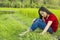 Teen girl Asian sitting in rice field thinking and smiling happily reminded of past great story