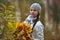 Teen girl in the autumn park with maple leaves