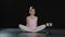 Teen girl dancer gymnast acrobat ballerina child making butterfly stretch exercise sitting on floor in dance studio hips