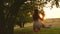 Teen girl enjoys a flight on a swing on a summer evening in the forest. young girl swinging on a rope swing on an oak