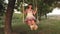 Teen girl enjoys a flight on a swing on a summer evening in the forest. young girl swinging on a rope swing on an oak