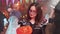 Teen girl in evil witch costume with a jack-o-lantern in her hands