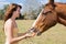 Teen Girl Feeds Horse