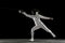 Teen girl in fencing costume with sword in hand isolated on black background