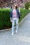 Teen girl in glasses walking in a flowered sakura park. walk in early spring