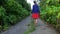 Teen girl goes along abandoned road overgrown by hogweed