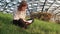 Teen girl in a gray shirt sitting on the grass in the park and reading a notebook with lecture notes on a sunny day