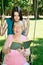 Teen girl and her grandmother read a book in the park vertical