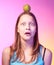 Teen girl holding an apple on her head as a target