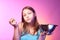 Teen girl holding a colander full of apples and eating an apple