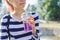 Teen girl holding glass with straw with purple drink in hand