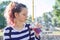 Teen girl holding glass with straw with purple drink in hand