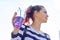 Teen girl holding glass with straw with purple drink in hand