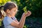 Teen girl holding in hands green young plant. little farmer. gardening