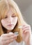 Teen girl holds blue eye lens