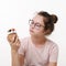 Teen girl holds sweet cream cake in her hand and wants to eat, white background