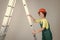 teen girl laborer in protective helmet and uniform on ladder, building