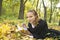 Teen girl lies in autumn park with her diary