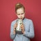 Teen girl looking at money cash in jar on pink background