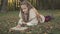 Teen girl lying in grass at the forest edge reading