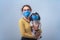 Teen girl in a medical mask holds a dog in a protective mask
