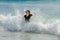 Teen Girl in the Ocean Facing the Shore With Arms Outstretched B