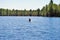 Teen girl paddle boarding in the middle of a lake upper peninsula michigan