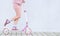 Teen girl in pink clothes riding on a pink scooter on a white background. Legs and scooter