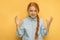 Teen girl playfully scares on yellow background