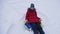 Teen girl plays in a winter park on christmas holidays. girl slides in winter in snow from high hill on sled and an